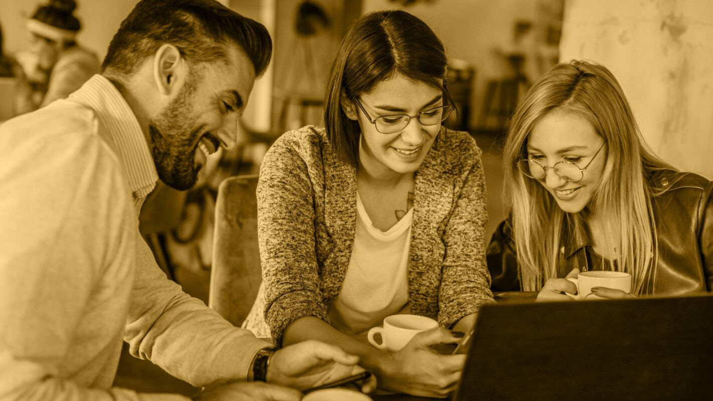 3 personen achter een laptop